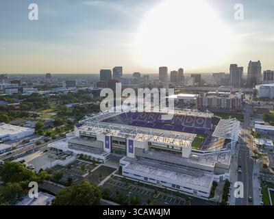 Orlando, USA - 21. Juli 2025: Aus der Vogelperspektive des sonnenverwöhnten Camping World Stadions, dessen violette Sitze einen starken Kontrast zum Stadtbild bilden. Stockfoto