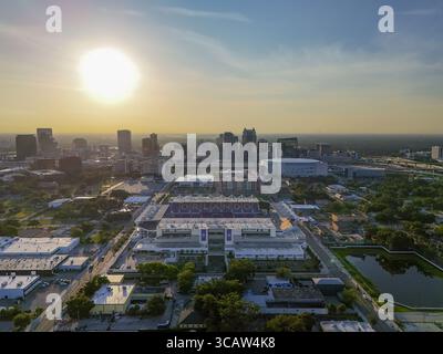 Orlando, Vereinigte Staaten - 21. Juli 2025: Aus der Vogelperspektive des Camping World Stadions, das im warmen Glanz der untergehenden Sonne getaucht ist und einen starken Kontrast zu den kühlen Blautönen der umliegenden Skyline der Stadt bildet. Stockfoto