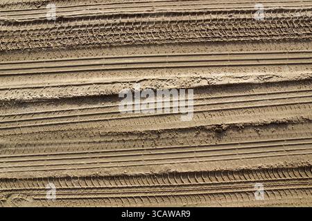 Spuren von Pkw-Reifen auf dem Sandweg Hintergrund. Sonnigen Tag Stockfoto