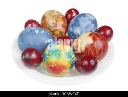 Osterhähnchen und Wachteleier mit natürlichem Lebensmittelfarbstoff bemalt - Zwiebelschalen und Kohl. Isoliert auf weißem Studio-Makro Stockfoto