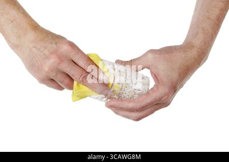 Der ältere Barkeeper wischt das Glas mit seinen Händen ab und eine saubere Serviette wischt ein leeres Kristallglas für Whiskey ab. Isoliert auf weißer Draufsicht Stockfoto
