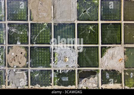 Gebrochenes altes grünes Glas blockiert die Hintergrundstruktur. Sonniger Tag Stockfoto