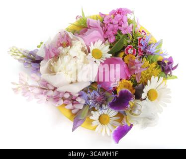 Gelber Teller mit Cocktail mit verschiedenen Blumen im Juni. Isoliert auf weiß Stockfoto