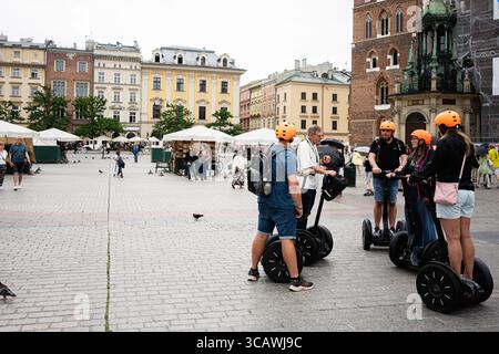 Krakau, Polen - 08. Juli 2025: Touristen auf Segways genießen eine geführte Erkundung des historischen Marktplatzes von Krakau. Stockfoto