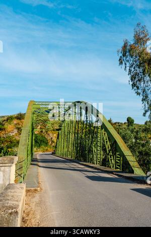 Grün lackiert und aus genietetem Stahl gefertigt, verbindet die Brücke Luis de Arminan die Provinzen Malaga und Cordoba in Spanien über den Fluss Genil, Surro Stockfoto