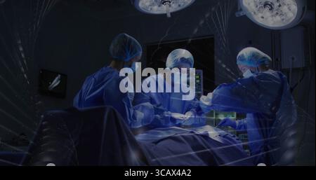 Operationsteam, das im OP operiert, mit Lichtern und Operationstisch trägt Stockfoto