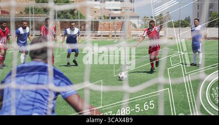 Der Stürmer mit rotem Trikot bereitet den Freistoß auf dem städtischen Fußballfeld vor, mit Fußball und Netz Stockfoto