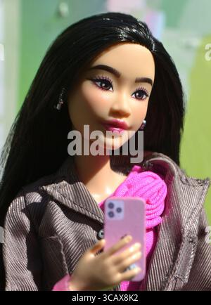 Asian Deluxe Barbie Puppe auf ihrem Handy Stockfoto