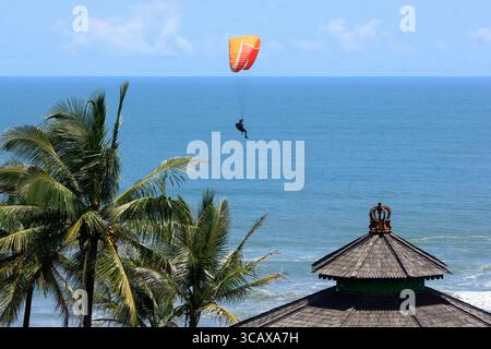 Gleitschirmflieger fliegen bei sonnigem Wetter am Strand von Parangtritis vorbei. Stockfoto