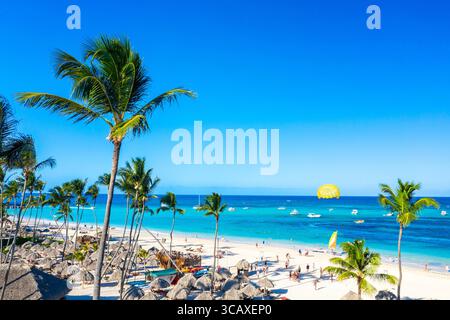 Blick aus der Vogelperspektive auf den Bavaro Strand Punta Cana tropisches Resort in der Dominikanischen Republik. Wunderschöner tropischer atlantikstrand mit Palmen, Sonnenschirmen und Parasailing Stockfoto