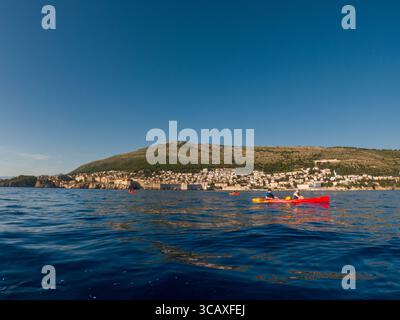 Dubrovnik, Kroatien - 12. September 2023: Kajakfahrer genießen eine Tour bei Sonnenuntergang in der Nähe der Stadtmauern. Stockfoto