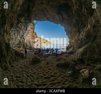 Dubrovnik, Kroatien - 12. September 2023: Kajakfahrer treffen sich an einem Strand während einer Tour bei Sonnenuntergang und bereiten sich auf den Start in die Adria vor. Stockfoto