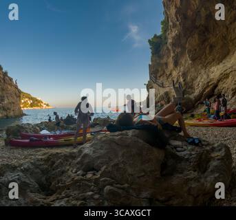 Dubrovnik, Kroatien - 12. September 2023: Touristen entspannen sich nach einer Kajaktour bei Sonnenuntergang und genießen den Strand und die wunderschöne Landschaft. Stockfoto
