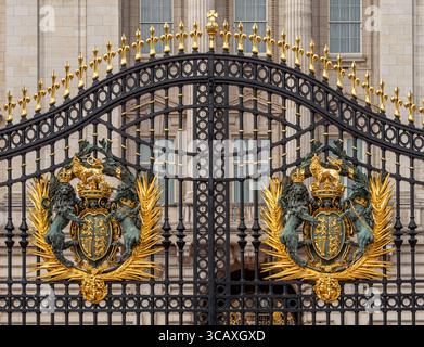 Das kunstvoll verzierte schwarze und vergoldete Eisen der Haupttore zum Buckingham Palace, mit dem Royal Wappen, London, Großbritannien. Stockfoto