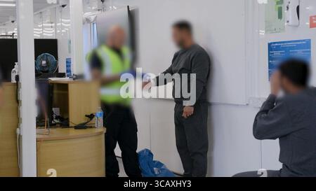HINWEIS FÜR DIE REDAKTION: FILMMATERIAL IST AN DER QUELLE VERSCHWOMMEN. Screenshot aus dem Video des Innenministeriums der Grenzschutzbeamten, das die ersten kleinen Migranten verarbeitet, die im Rahmen des neuen britischen „One in, One Out“-Deals bei Western Jet Foil in Dover, Kent festgehalten wurden. Die Migranten, die am Tag der Inbetriebnahme des Pilotprogramms inhaftiert wurden, durchlaufen in den letzten 24 Stunden die ersten Phasen des Pilotprozesses für die Rückkehr zwischen Großbritannien und Frankreich, einschließlich der Erstbearbeitung, biometrischer und Sicherheitskontrollen sowie der Umsiedlung in das Abschiebungszentrum für Einwanderer, um auf ihre Rückkehr nach Frankreich zu warten. Bilddatum: Donnerstag, 7. August, Stockfoto