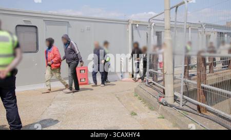 HINWEIS FÜR DIE REDAKTION: FILMMATERIAL IST AN DER QUELLE VERSCHWOMMEN. Screenshot aus dem Video des Innenministeriums der ersten Migranten mit kleinen Booten, die im Rahmen des neuen britischen „One in, One Out“-Deals bei Western Jet Foil in Dover, Kent festgehalten wurden. Die Migranten, die am Tag der Inbetriebnahme des Pilotprogramms inhaftiert wurden, durchlaufen in den letzten 24 Stunden die ersten Phasen des Pilotprozesses für die Rückkehr zwischen Großbritannien und Frankreich, einschließlich der Erstbearbeitung, biometrischer und Sicherheitskontrollen sowie der Umsiedlung in das Abschiebungszentrum für Einwanderer, um auf ihre Rückkehr nach Frankreich zu warten. Bilddatum: Donnerstag, 7. August 2025. Stockfoto