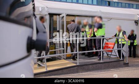 HINWEIS FÜR DIE REDAKTION: FILMMATERIAL IST AN DER QUELLE VERSCHWOMMEN. Screenshot aus dem Video des Innenministeriums der Grenzschutzbeamten, das die ersten kleinen Migranten verarbeitet, die im Rahmen des neuen britischen „One in, One Out“-Deals im Manston Immigration Processing Centre in Manston, Kent, festgehalten wurden. Die Migranten, die am Tag der Inbetriebnahme des Pilotprogramms inhaftiert wurden, durchlaufen in den letzten 24 Stunden die ersten Phasen des Pilotprozesses für die Rückkehr zwischen Großbritannien und Frankreich, einschließlich der Erstbearbeitung, biometrischer und Sicherheitskontrollen sowie der Umsiedlung in das Abschiebungszentrum für Einwanderer, um auf ihre Rückkehr nach Frankreich zu warten. Bild Stockfoto