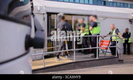 HINWEIS FÜR DIE REDAKTION: FILMMATERIAL IST AN DER QUELLE VERSCHWOMMEN. Screenshot aus dem Video des Innenministeriums der Grenzschutzbeamten, das die ersten kleinen Migranten verarbeitet, die im Rahmen des neuen britischen „One in, One Out“-Deals im Manston Immigration Processing Centre in Manston, Kent, festgehalten wurden. Die Migranten, die am Tag der Inbetriebnahme des Pilotprogramms inhaftiert wurden, durchlaufen in den letzten 24 Stunden die ersten Phasen des Pilotprozesses für die Rückkehr zwischen Großbritannien und Frankreich, einschließlich der Erstbearbeitung, biometrischer und Sicherheitskontrollen sowie der Umsiedlung in das Abschiebungszentrum für Einwanderer, um auf ihre Rückkehr nach Frankreich zu warten. Bild Stockfoto