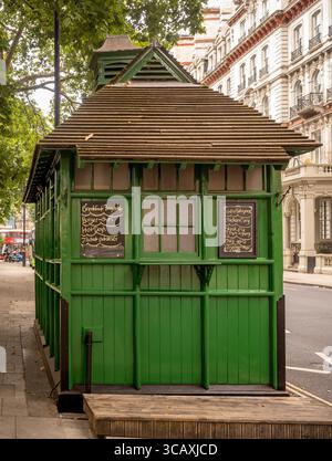 Ein Menü auf der Tafel an der Seite eines historischen grünen Cabman's Shelter in Grosvenor Gardens, London, Großbritannien. Stockfoto
