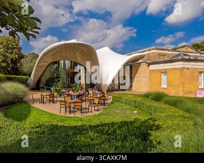 Die Gäste speisen vor dem Restaurant „The Magazine“ in der Serpentine North Gallery in der modernen Anlage, die von Zaha Hadid, London, Großbritannien, entworfen wurde. Stockfoto
