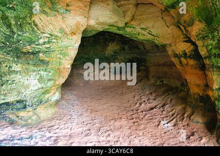 Farbenfrohe Sandsteinhöhle mit Moos und strukturierten Wänden Stockfoto