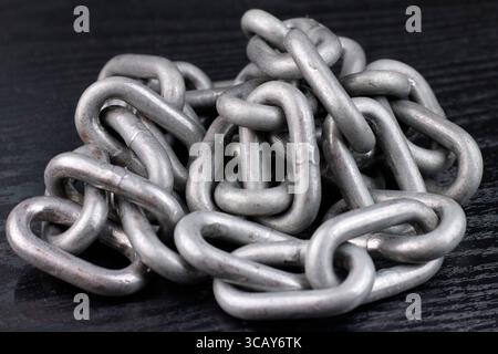 Nahaufnahme eines Stapels eiserner Ketten auf schwarzem Hintergrund. Stockfoto