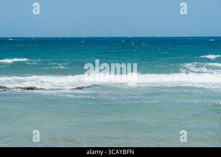 Malerischer Blick auf die Wellen, die unter einem klaren blauen Himmel an die Küste stürzen. Eine ruhige Meereslandschaft, die die Schönheit der Natur und das offene Meer einfängt Stockfoto
