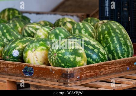 Frische ganze Wassermelonen in einer Holzkiste auf einem Obst- und Gemüsemarkt Stockfoto