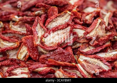 Sonnengetrocknete Tomaten in einem Korb auf einem Straßenmarkt, Nahaufnahme. Reife Tomaten verlieren den größten Teil ihres Wassergehalts Stockfoto