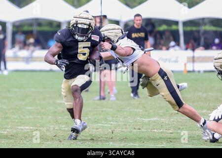 Metairie, Usa. August 2025. Running Back Kendre Miller (5) läuft am 3. August 2025 in Metairie, Louisiana, am Linebacker Danny Stutsman (47) im Trainingscamp der New Orleans Saints im Ochsner Sports Performance Center vorbei. (Foto: Peter G. Forest/SIPA USA) Credit: SIPA USA/Alamy Live News Stockfoto