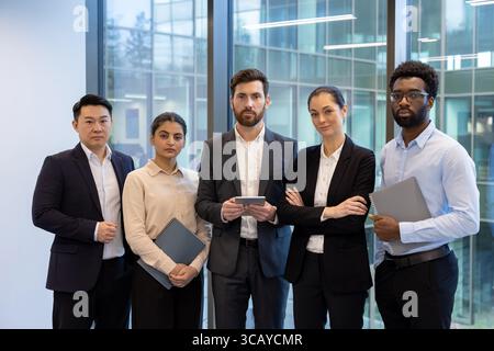 Eine Gruppe von Fachleuten, die gemeinsam in einer modernen Büroumgebung Teamarbeit und Führung zeigen. Stockfoto