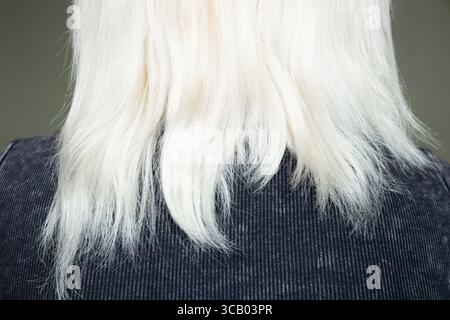Geschädigtes trockenes blondes Haar eines Mädchens von hinten, brüchige Enden nach Färben, Haarpflege und -Behandlung, geschädigtes Strukturkonzept Stockfoto