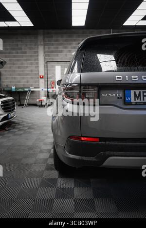 Rückansicht des Silver Range Rover Discovery Sport in der modernen Garage Stockfoto