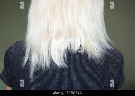 Geschädigtes trockenes blondes Haar eines Mädchens von hinten, brüchige Enden nach Färben, Haarpflege und -Behandlung, geschädigtes Strukturkonzept Stockfoto