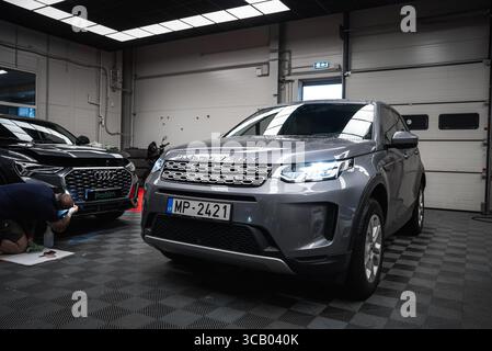 Silver Land Rover Discovery und Black Audi in moderner Garage Stockfoto
