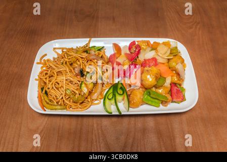 Gebratene Nudeln nach Peking-Art: Scharfes Schweinefleisch mit Bambussprossen, Shiitake-Pilzen und Udon-Nudeln, garniert mit gerösteten Sesamsamen Stockfoto