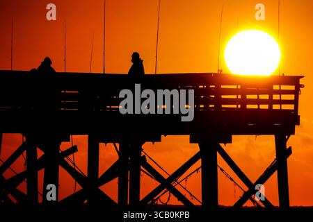 24. Oktober 2023, Isle of Palms, SC, Vereinigte Staaten: Fischer, die von Sonnenaufgang umgeben sind, warten am Isle of Palms Pier, 24. Oktober 2023 in Isle of Palms, South Carolina, auf den Fisch. (Bild: © Richard Ellis/ZUMA Press Wire) Stockfoto