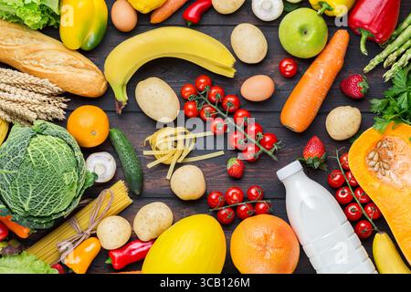 Rahmen für Gemüse- und Obstsortiment auf dunklem Holztisch. Vegetarisches gesundes Lebensmittelkonzept. Essen und Lebensmittelgeschäfte Stockfoto