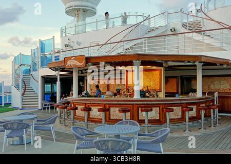 Open-Air-Bar auf dem Deck eines luxuriösen Kreuzfahrtschiffs bei Sonnenuntergang Stockfoto