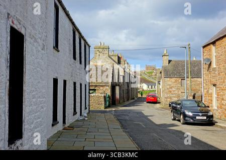 Eine typische Straße mit alten Steinhäusern im kleinen malerischen Fischerdorf St. Margaret's Hope auf der Insel South Ronaldsay in Orkney, Schottland Stockfoto