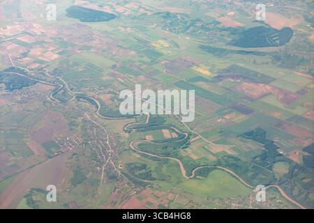Der sich schlängelnde Fluss durchquert das bebaute Land und schafft ein wunderschönes Muster von oben. Blick aus der Vogelperspektive auf die Landschaft, die den Taucher hervorhebt Stockfoto