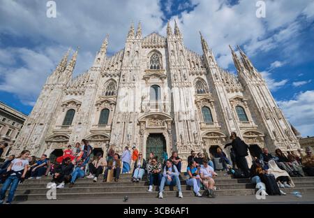Flacher Blick auf die Vorderfassade an einem sonnigen, klaren Tag mit traumhaft blauem Himmel und weißen, geschwollenen Wolken. Im Duomo in Mailand, Italien. Stockfoto