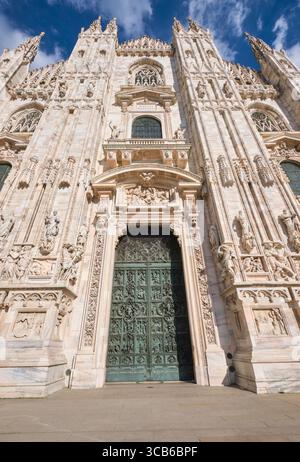 Flacher Blick auf die Vorderfassade an einem sonnigen, klaren Tag mit traumhaft blauem Himmel und weißen, geschwollenen Wolken. Im Duomo in Mailand, Italien. Stockfoto