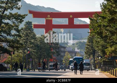 Eine lebhafte Szene des Okazaki Parks, der zum Heian-Jingu-Schrein Grand Torii führt, umgeben von Grün und Gebäuden unter klarem Himmel. Okazaki Seishoji Stockfoto