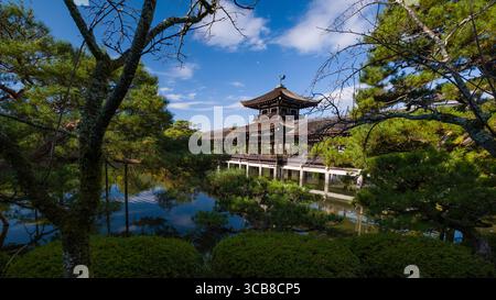 Heian Jingu Taiheikaku Pavillon umgeben von grünem Grün und ruhigen Wasserspiegeln unter einem leuchtend blauen Himmel, der die Harmonie der Tradition einfängt Stockfoto