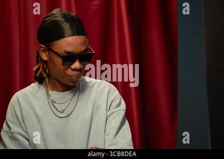 Junger schwarzer Mann mit Sonnenbrille, der während des Talentwettbewerbs auf der Bühne auftritt Stockfoto