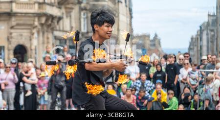 Edinburgh, Großbritannien. August 2025. August 2025 Edinburgh, Edinburgh Fringe Festival. Der Edinburgh Fringe ist jetzt in vollem Gange und die Menschenmassen strömen zur Royal Mile, um die vielen Talente und Sehenswürdigkeiten und Klänge der Straßenkünstler zu erleben. Xiao Hei führt seine Feuershow vor den Menschenmassen durch PIC Credit: phil wilkinson/Alamy Live News Stockfoto