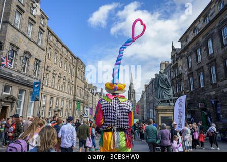 Edinburgh, Großbritannien. August 2025. August 2025 Edinburgh, Edinburgh Fringe Festival. Der Edinburgh Fringe ist jetzt in vollem Gange und die Menschenmassen strömen zur Royal Mile, um die vielen Talente und Sehenswürdigkeiten und Klänge der Straßenkünstler zu erleben. Straßenszene mit Clown und Ballons. PIC Credit: phil wilkinson/Alamy Live News Stockfoto