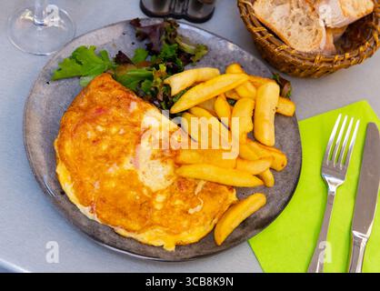 Portion Gourmet-Omelett mit gebratenen Kartoffeln Stockfoto