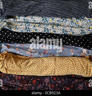 Foto von verschiedenen bedruckten Stoffen. In horizontalen Streifen auf dem Hintergrund angeordnet. Verschiedene Farben und Muster. Blumenmuster, Punktmuster, Ornamente. B Stockfoto